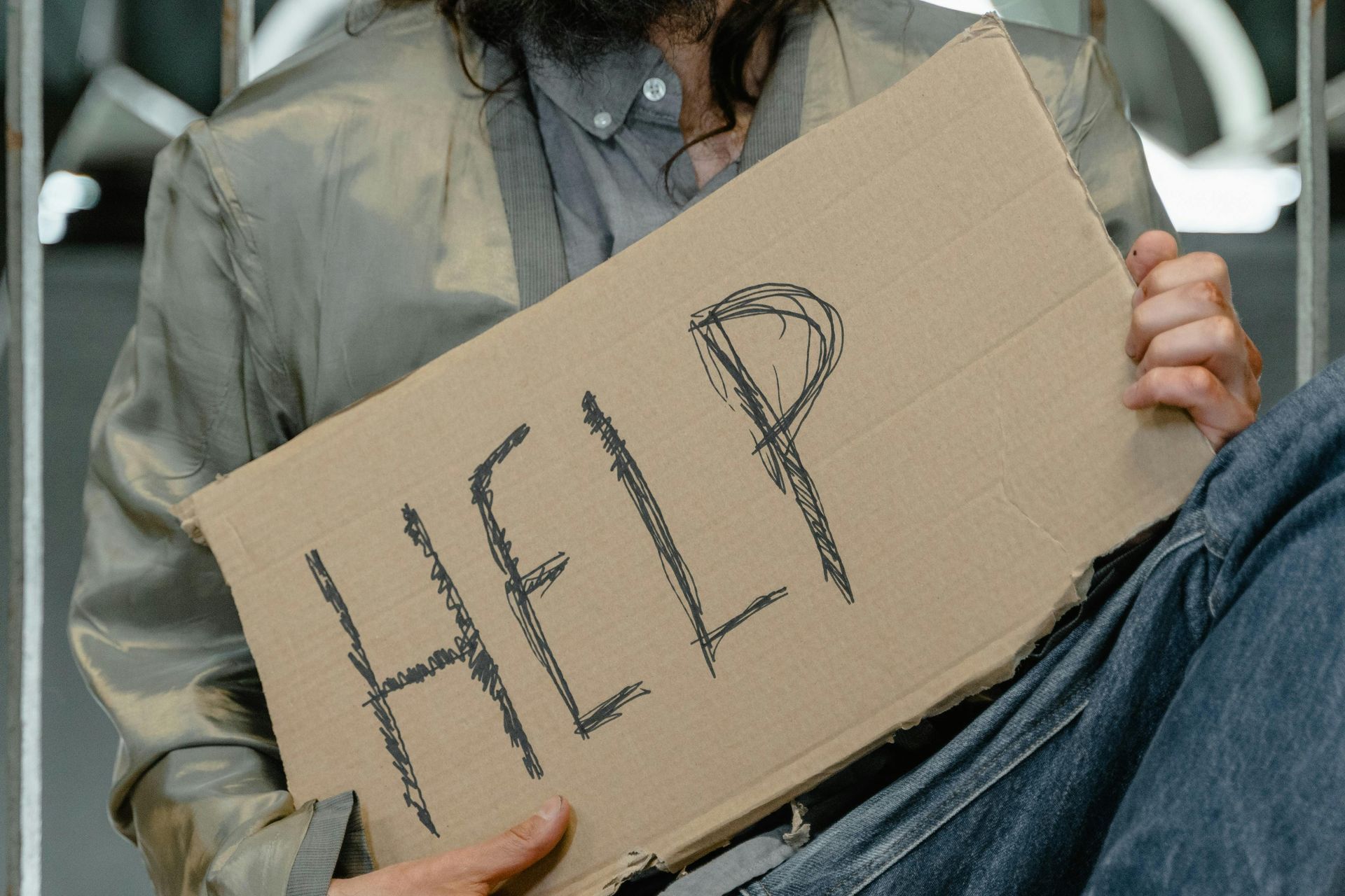 A person holds a piece of cardboard with the word