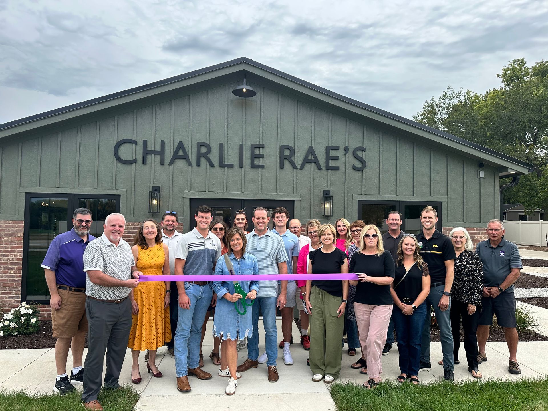 Group of people celebrating a ribbon-cutting event at 