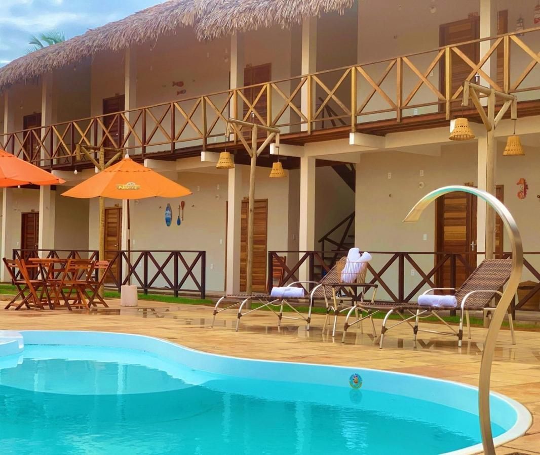Uma piscina em frente a um prédio com guarda-sóis e cadeiras