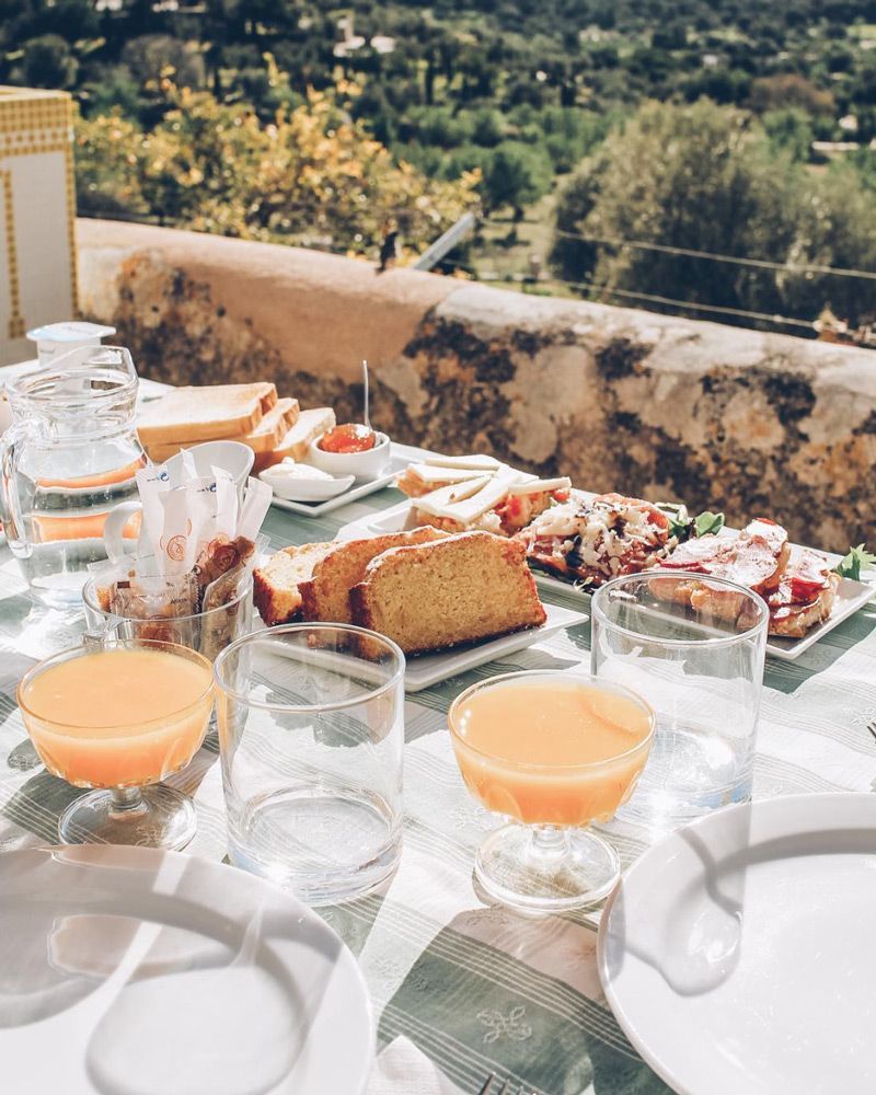 Una mesa cubierta con platos de comida y vasos de jugo de naranja.