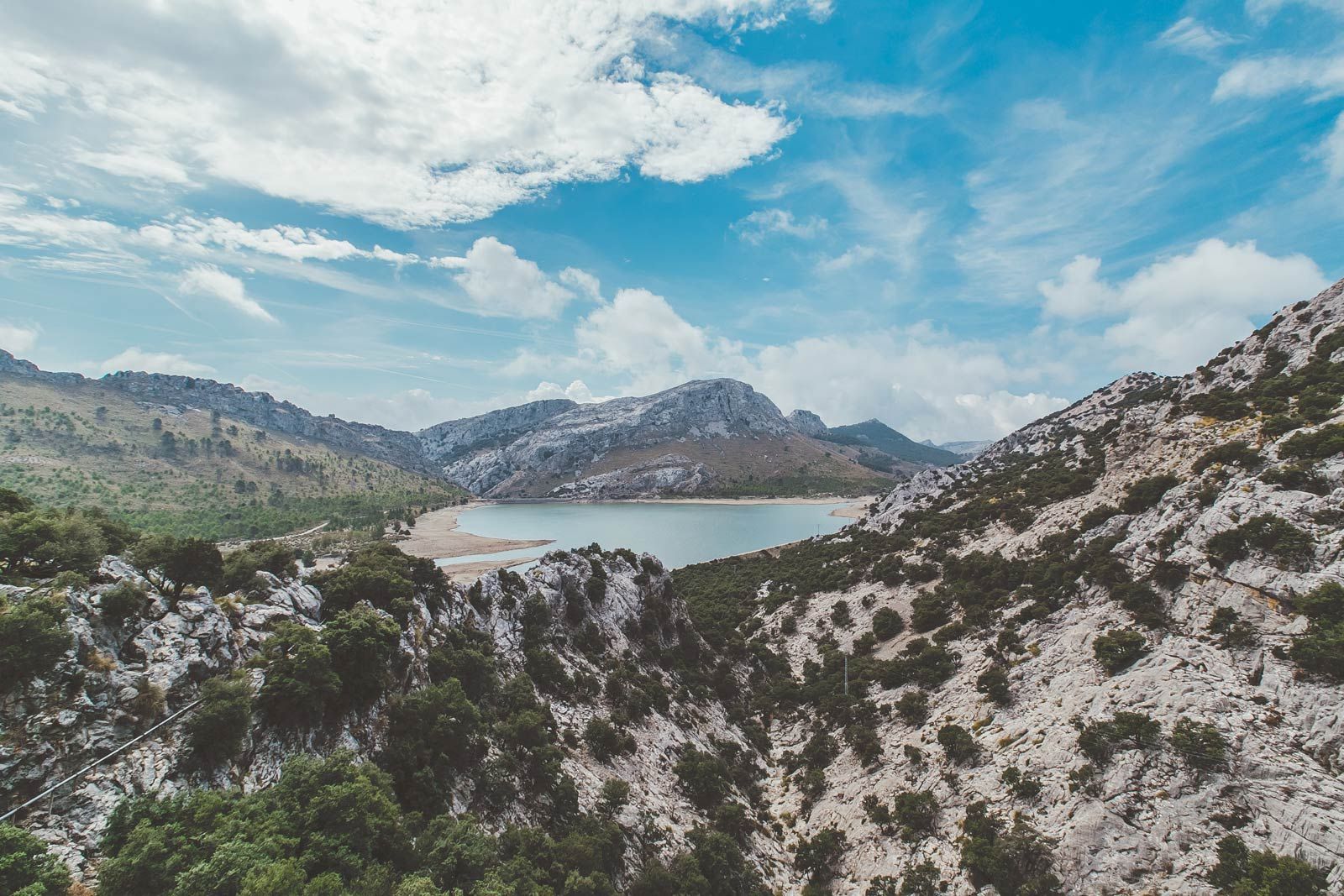Hay un lago en medio de las montañas rodeado de árboles.