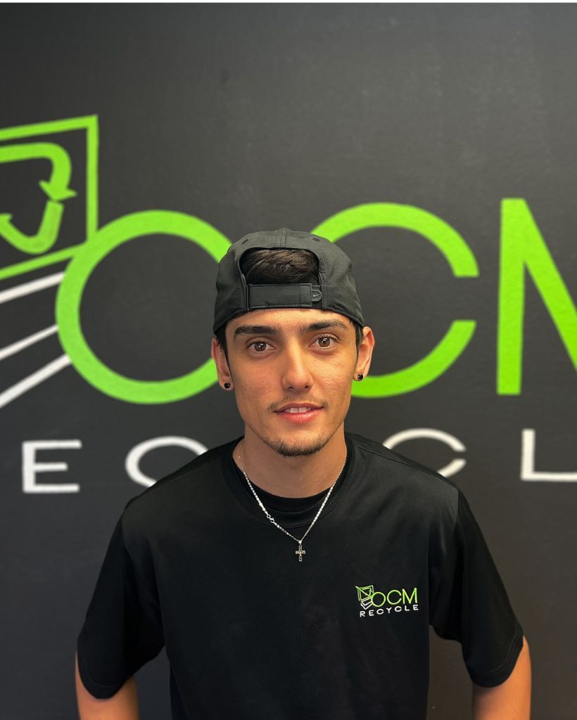 A man wearing a hat and a necklace stands in front of a cn logo