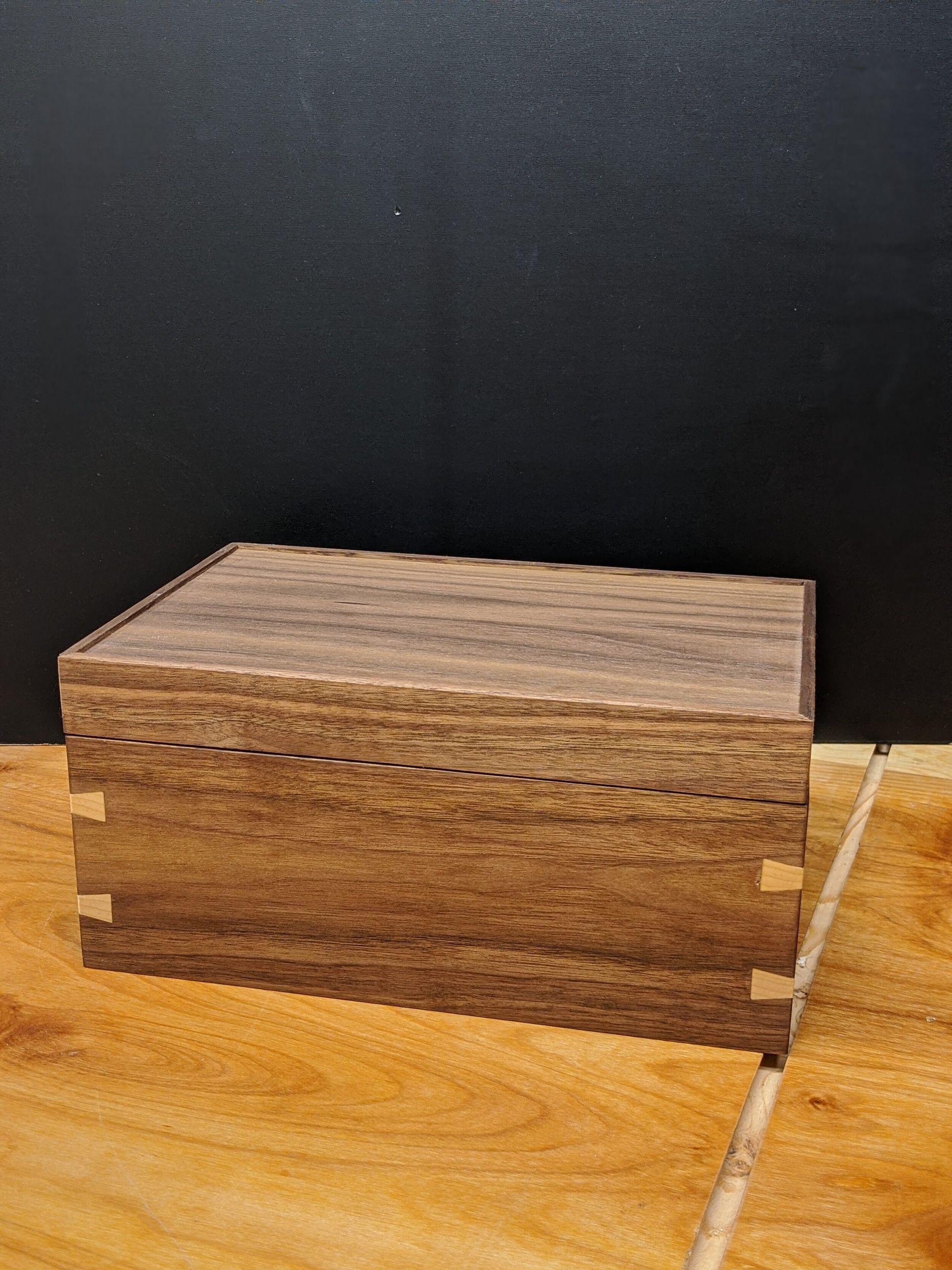 A small wooden box is sitting on a wooden table.