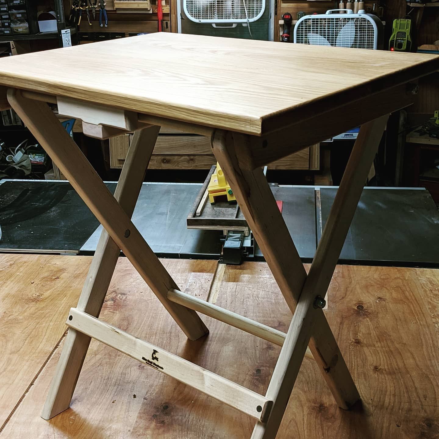 A wooden folding stool with the letter l on it