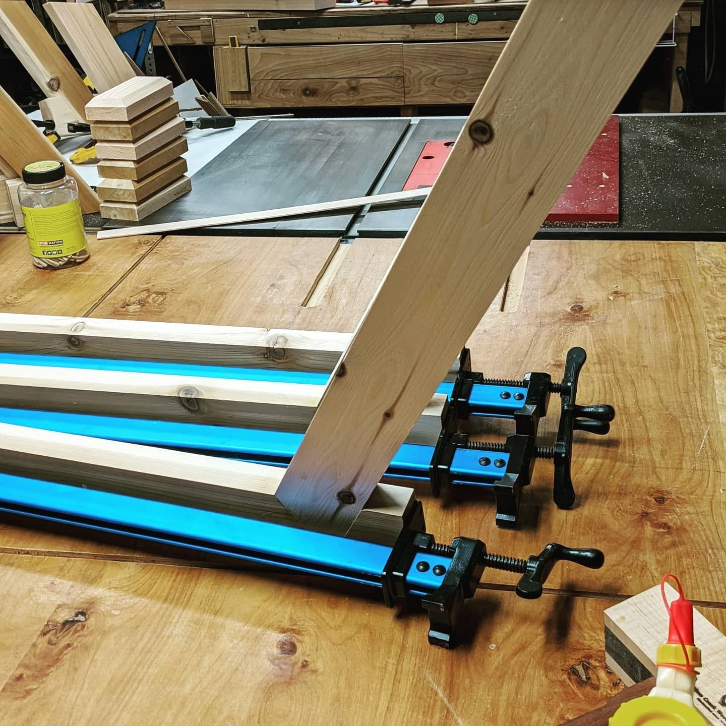 A wooden table with a bottle of glue on it