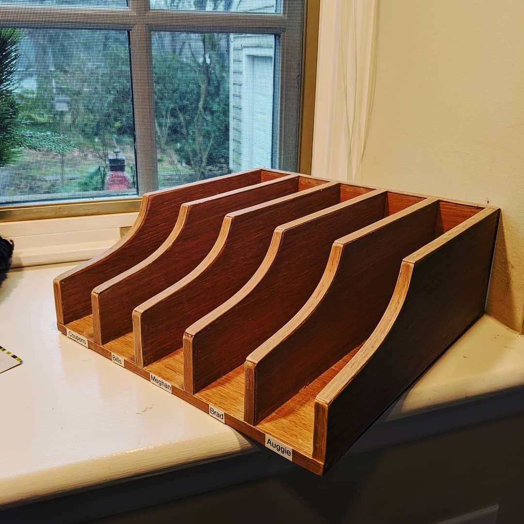 A wooden tray is sitting on a counter next to a window