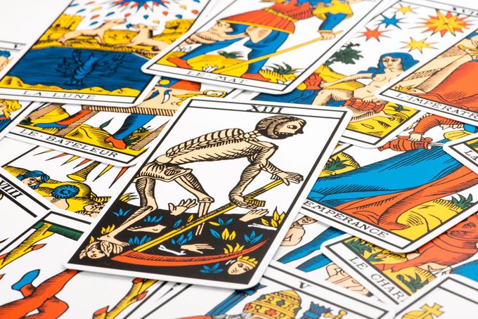 Una collezione di carte dei Tarocchi colorate sparse su una superficie, con la carta della Morte ben visibile al centro.
