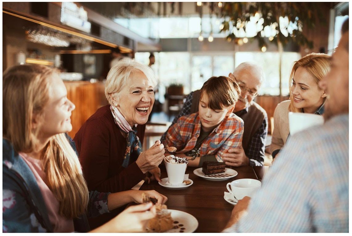 Friends chatting and smiling over coffee at a cozy café table