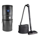 Black cylindrical vacuum canister with blue label beside a floor vacuum hose and head.