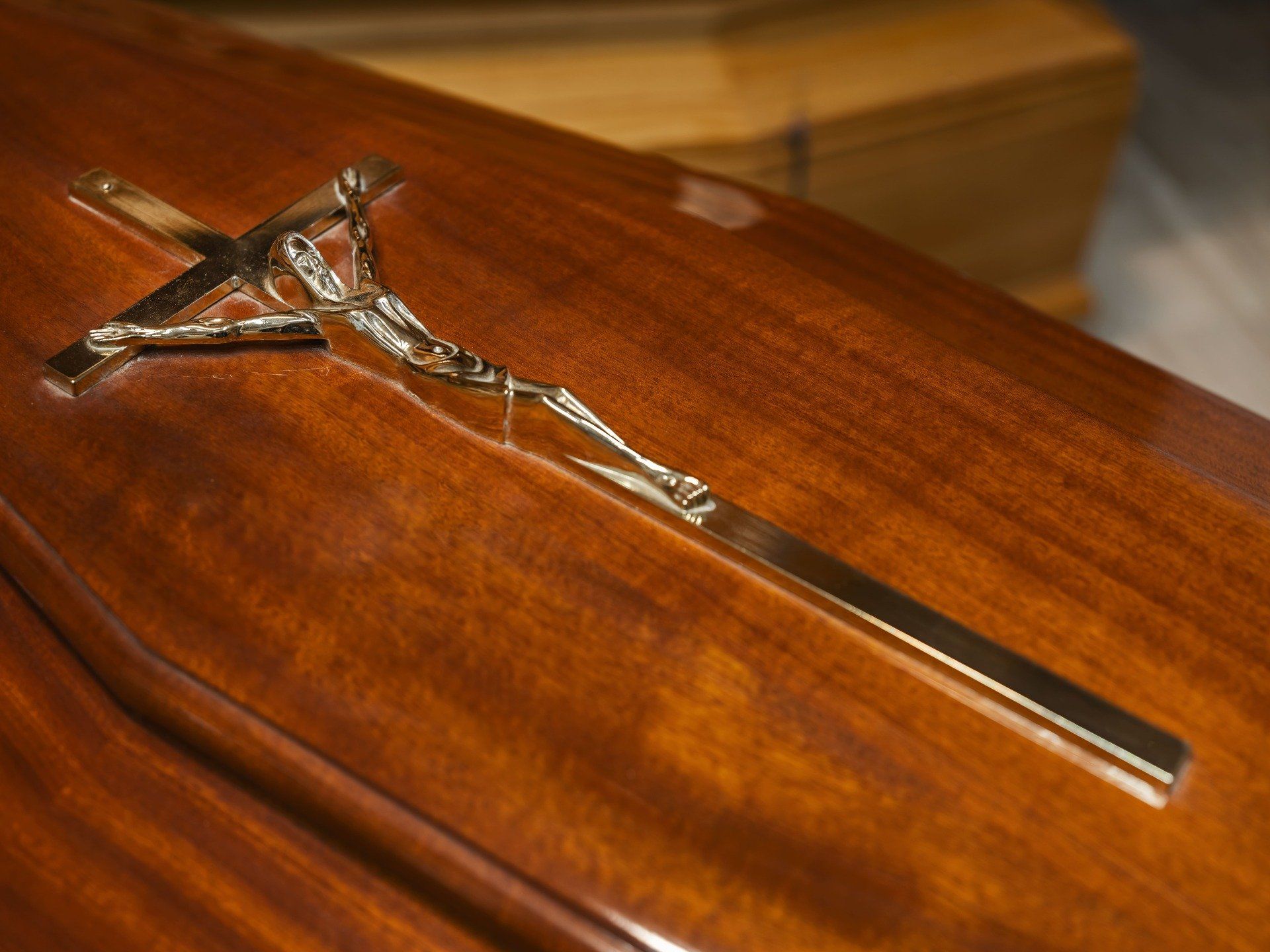 Ciondolo a croce in argento su base di legno, con lunga catena annessa.
