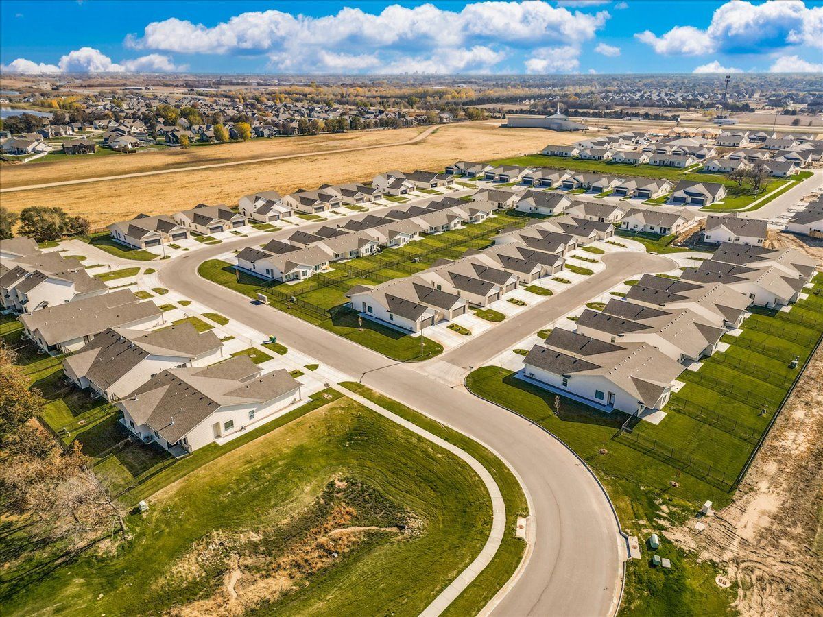 An aerial view of a residential neighborhood with lots of houses and a road.