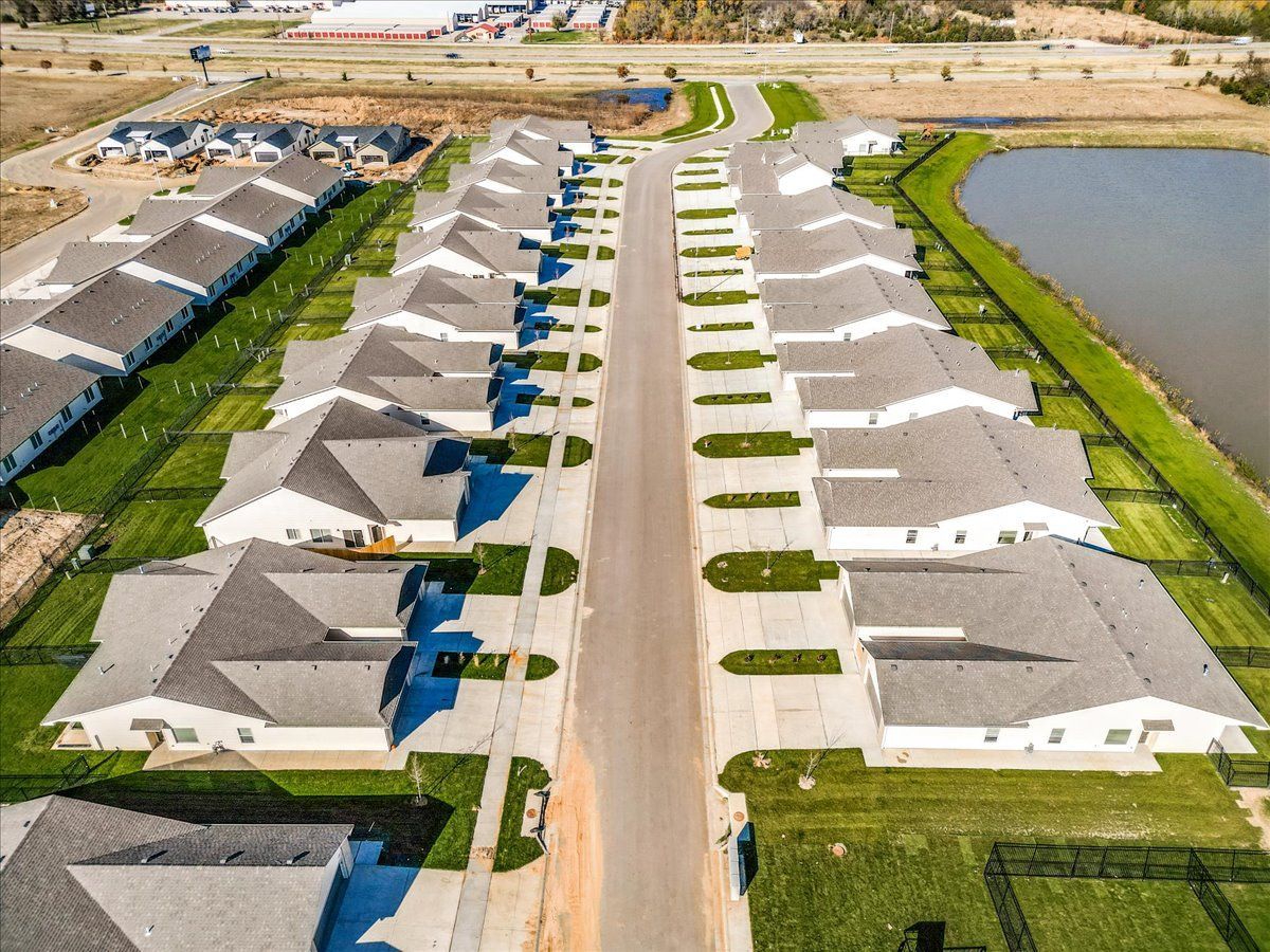 An aerial view of a residential neighborhood with a lake in the middle.