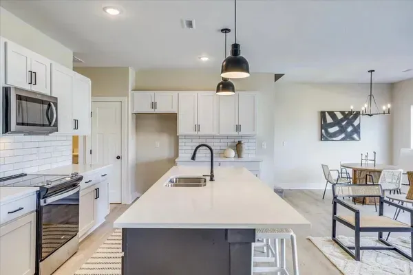 A kitchen with a large island and white cabinets