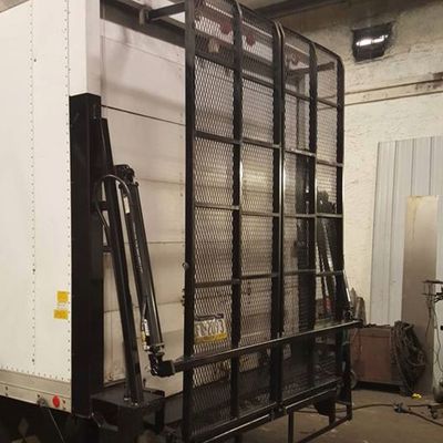 A white truck with a black cage on the back of it