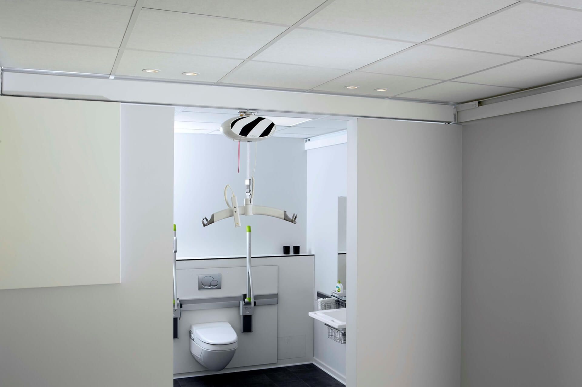 Ein Badezimmer mit Toilette, Waschbecken und Glasschiebetüren.