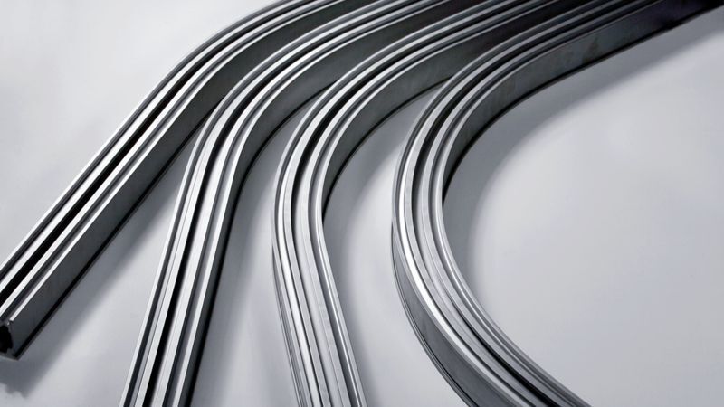 Eine Nahaufnahme eines Stapels Metallrohre auf einer weißen Oberfläche.