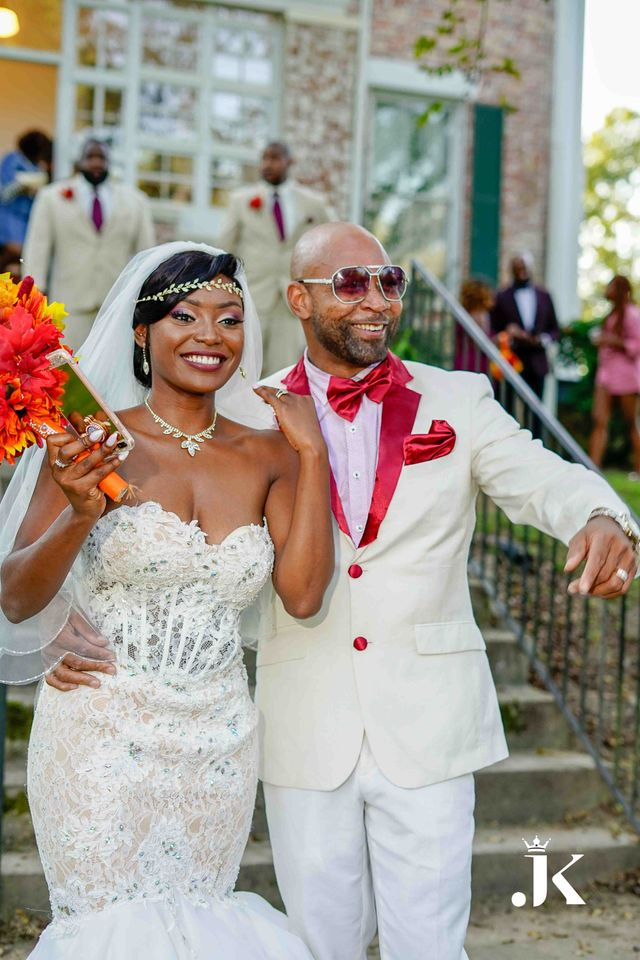 Wedding couple in white and red outfits posing outdoors on stone steps