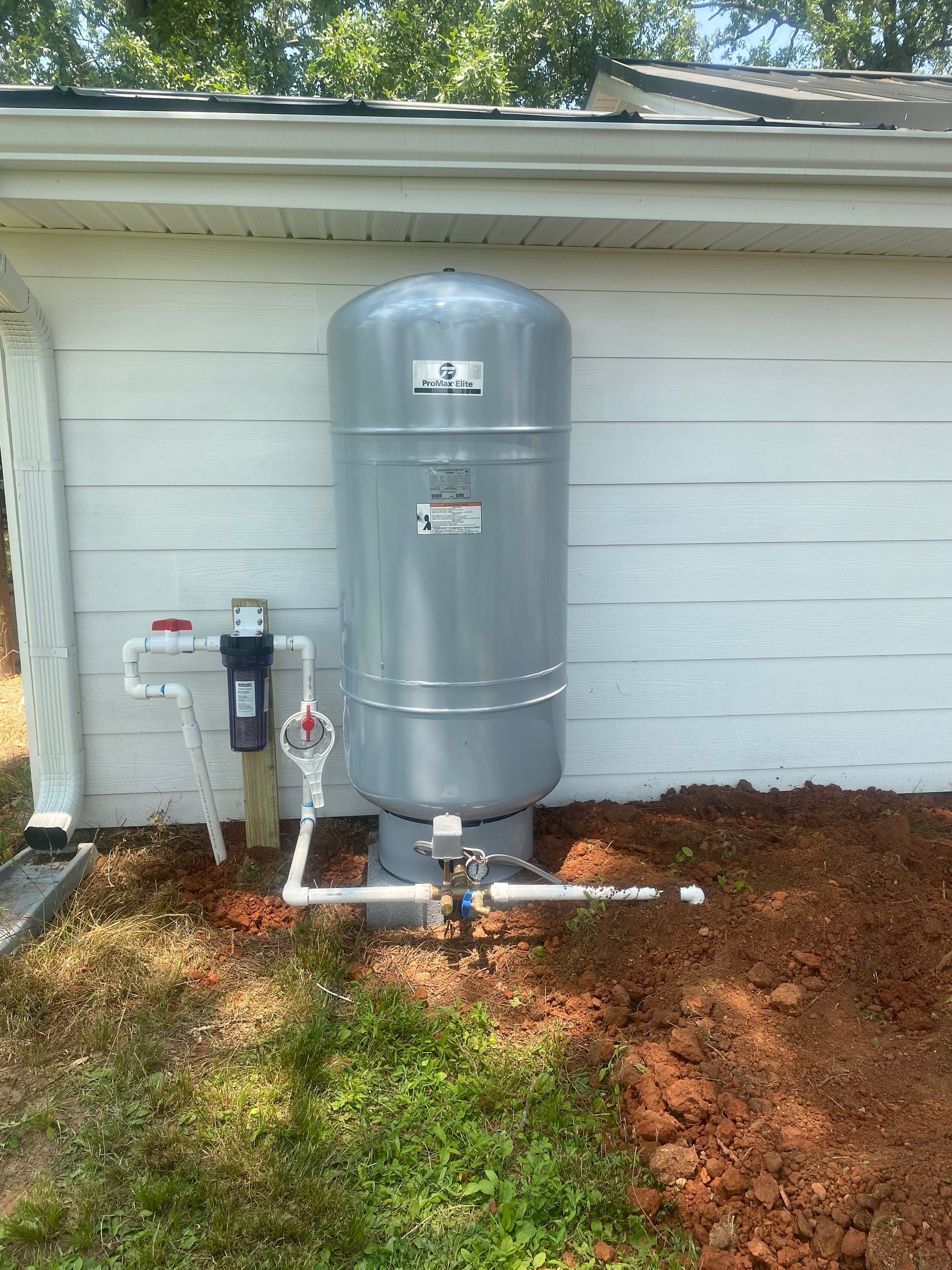 A water tank is attached to the side of a house.