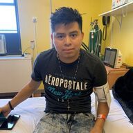 Man wearing an Aerospostale shirt, sitting on a hospital bed with blood pressure monitor.