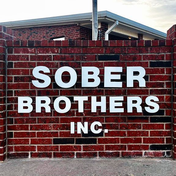 A brick wall with a sign that says sober brothers inc.