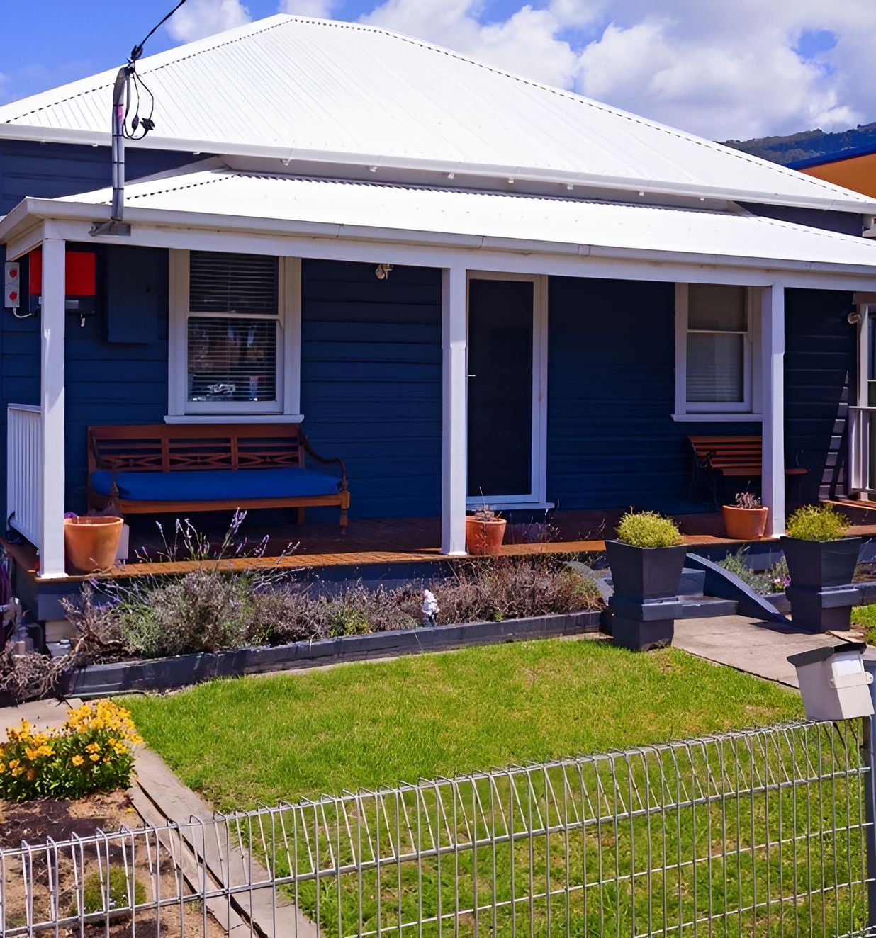 A Blue House With A White Roof And A Porch — Anytime Conveyancing In Wauchope, NSW