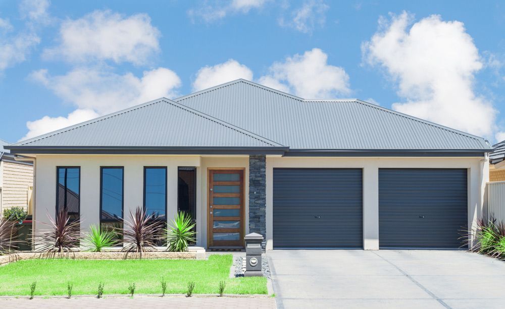A House With A Gray Roof And Two Garage Doors — Anytime Conveyancing In Old Bar, NSW