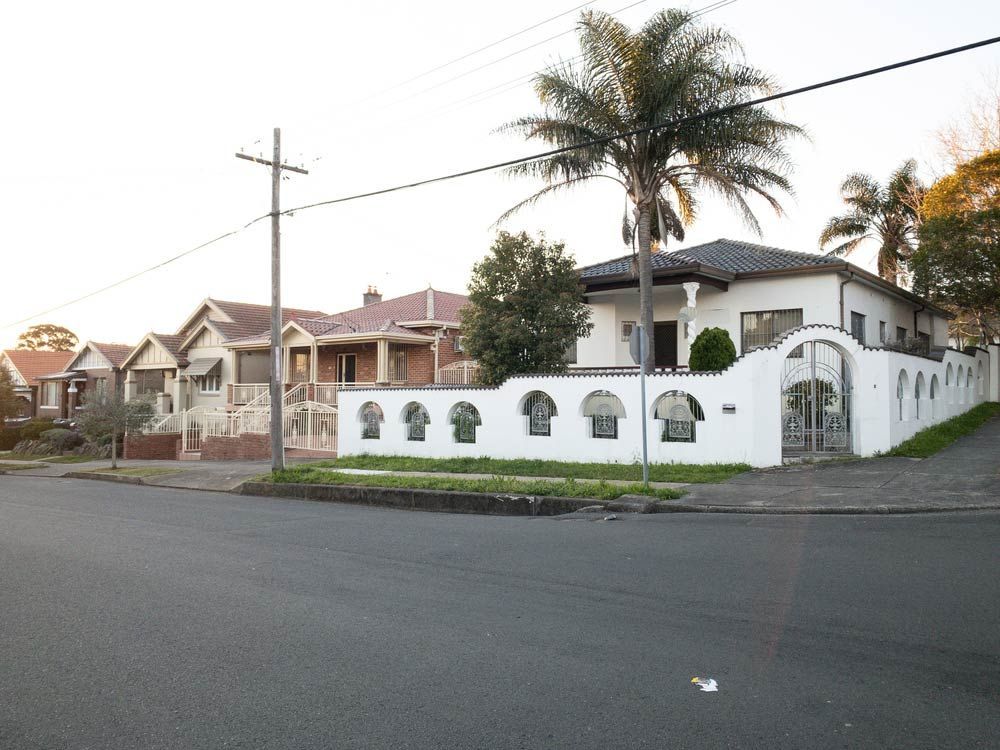 A White House With A Palm Tree In Front Of It — Anytime Conveyancing In Wingham, NSW