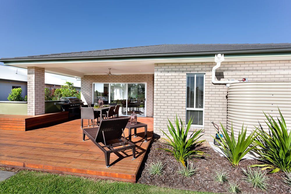 A House With A Wooden Deck And Chairs In Front Of It — Anytime Conveyancing In Taree, NSW