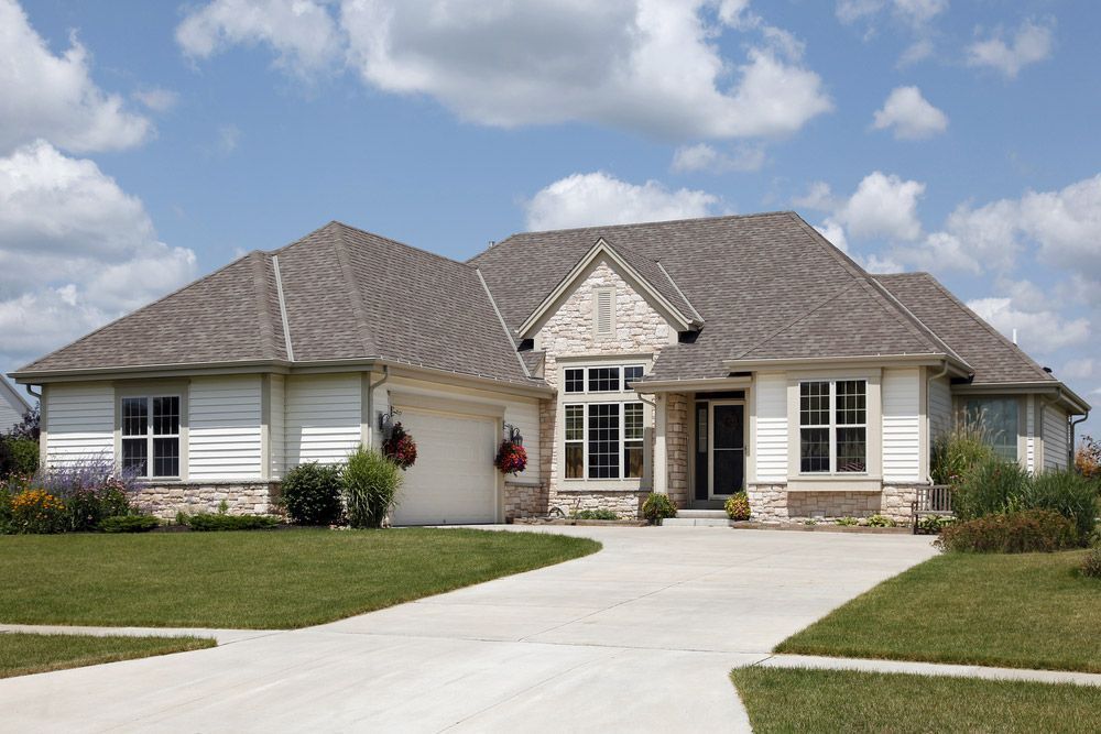 A Large White House With A Gray Roof And A Driveway — Anytime Conveyancing In Harrington, NSW