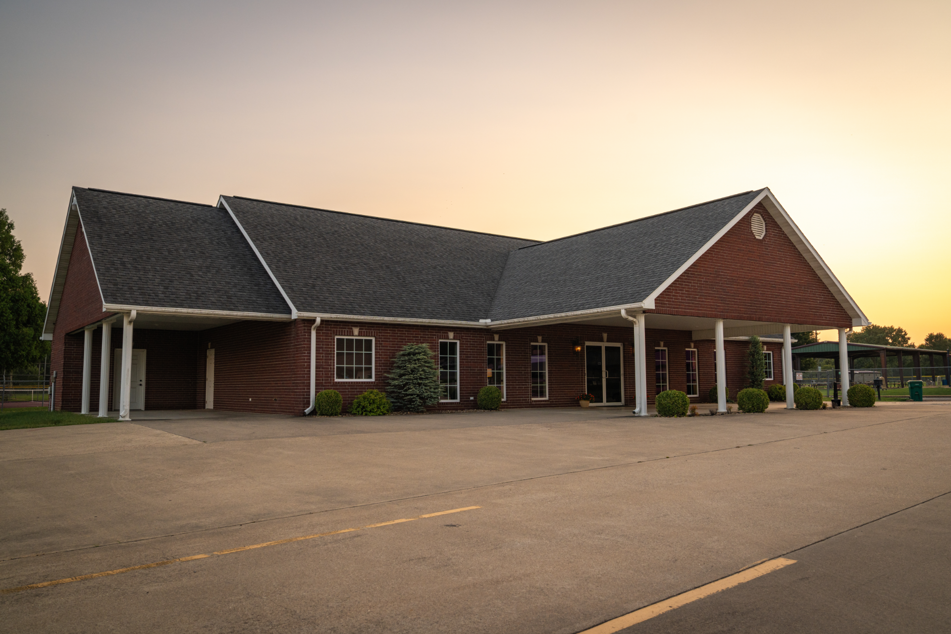 A large white building with a brown roof and a lot of windows.