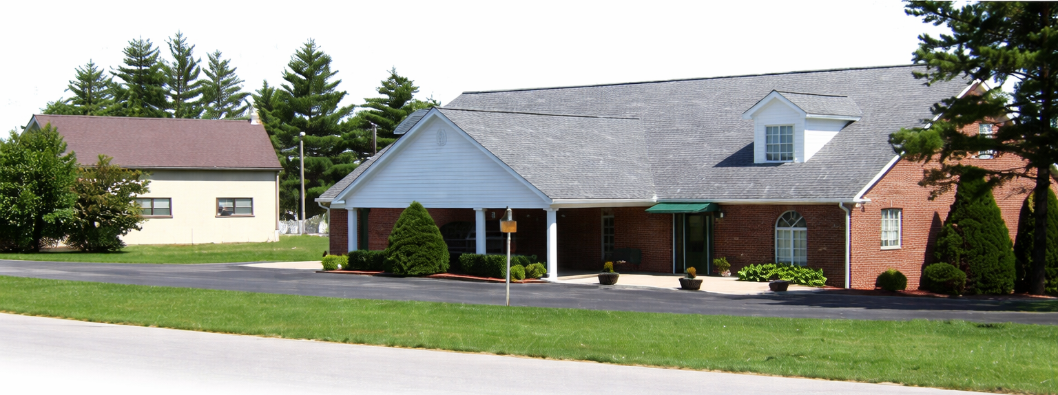 A large white building with a brown roof and a lot of windows.