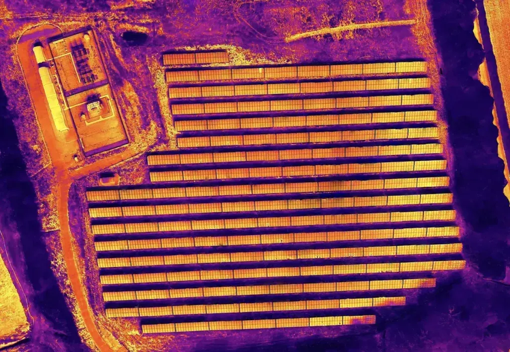 An aerial view of a row of solar panels in a field.