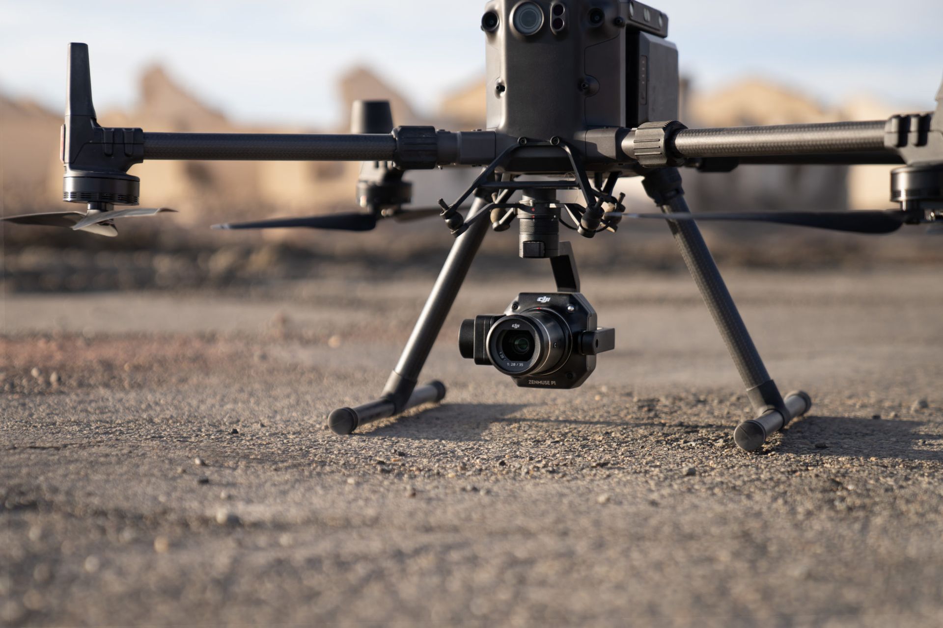 A drone with a camera attached to it is sitting on the ground.