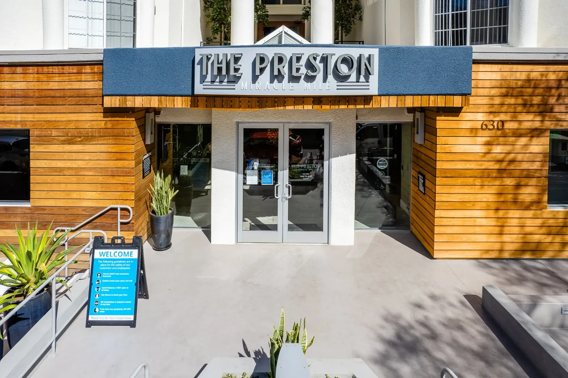 The Preston apartment building entrance with modern wood accents and signage.