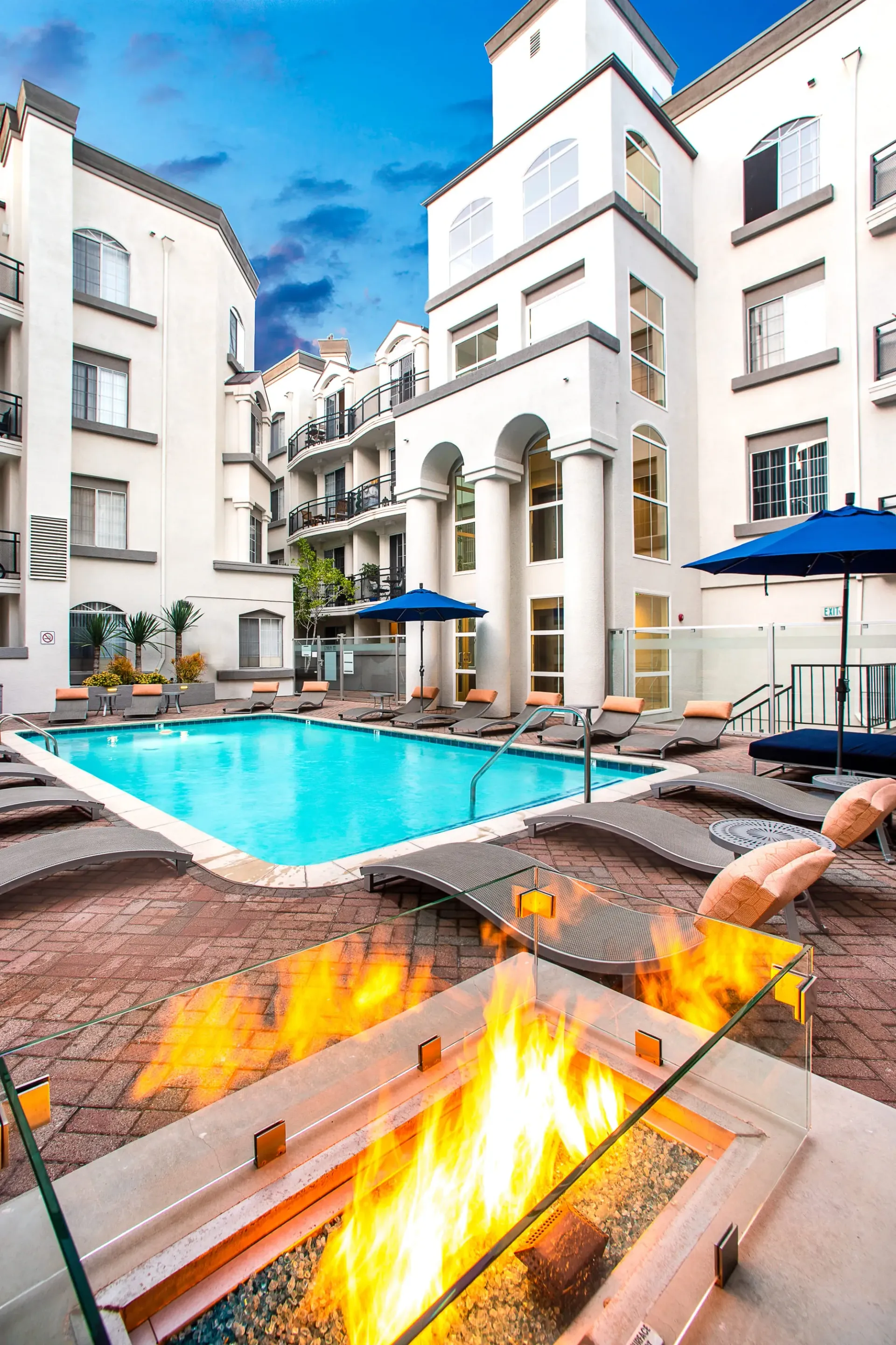 Luxury apartment building courtyard with a swimming pool and outdoor fire pit.