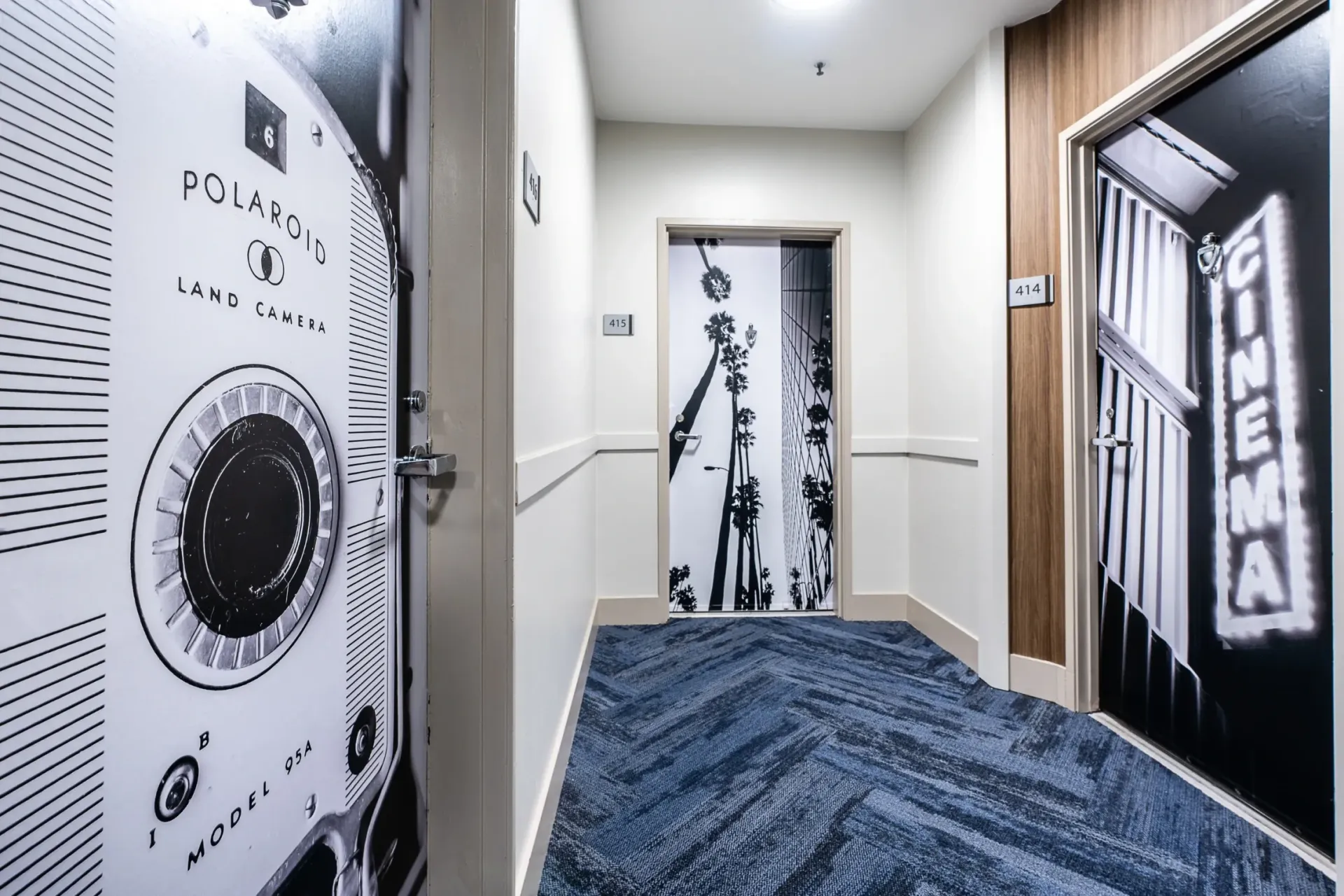 Hallway with graphic doors and blue patterned carpet