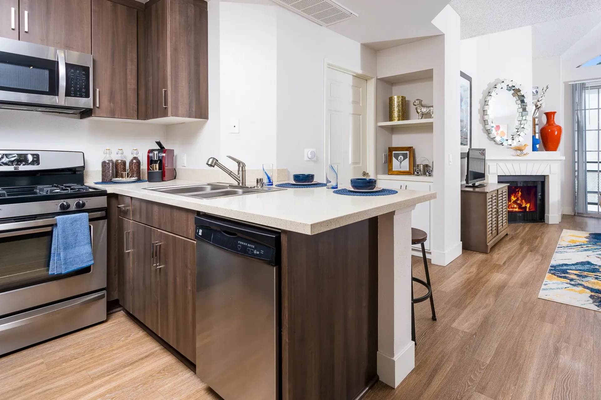 Modern kitchen with stainless steel appliances, quartz countertops, and dark wood cabinetry.