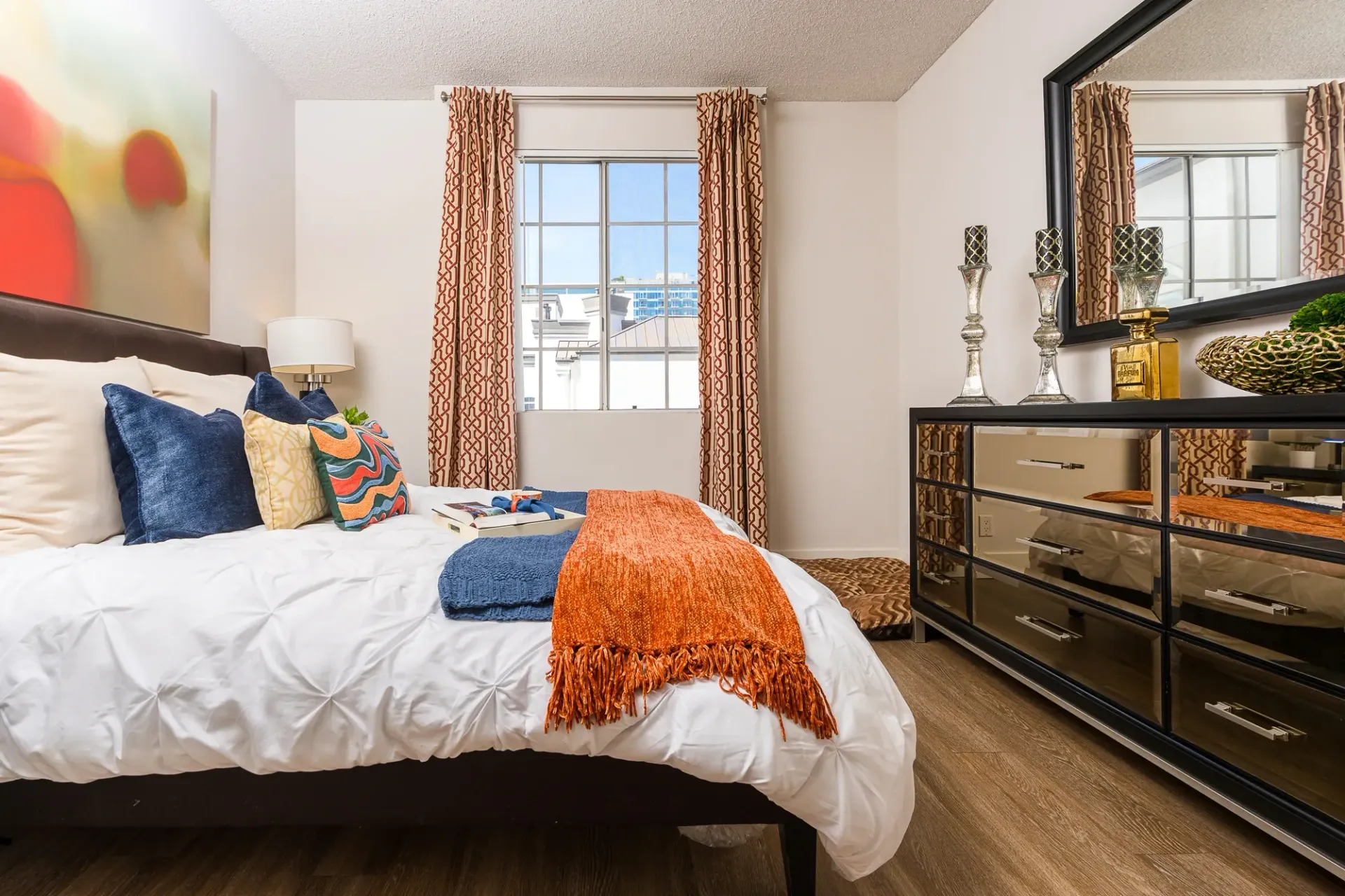 Well-appointed bedroom with a queen-size bed, plush bedding, and a modern dresser.