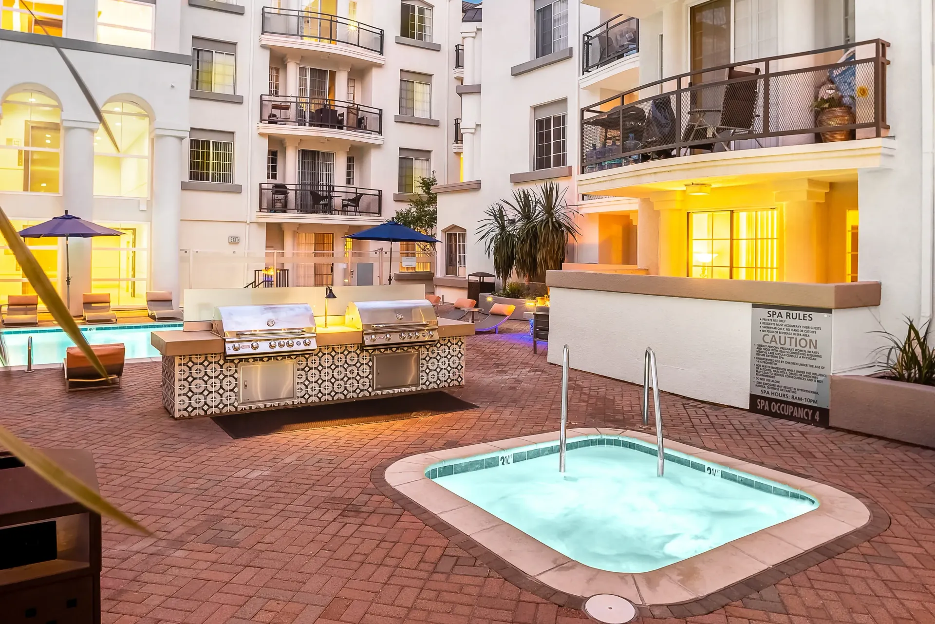 Outdoor communal area with grills, spa, and pool.