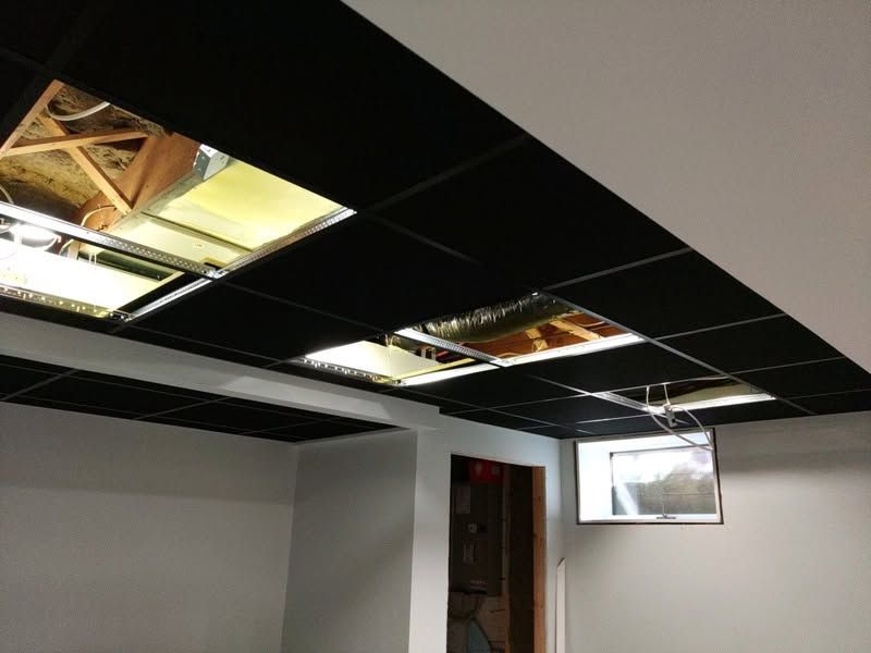 Partially demolished ceiling with exposed insulation and beams in an unfinished room