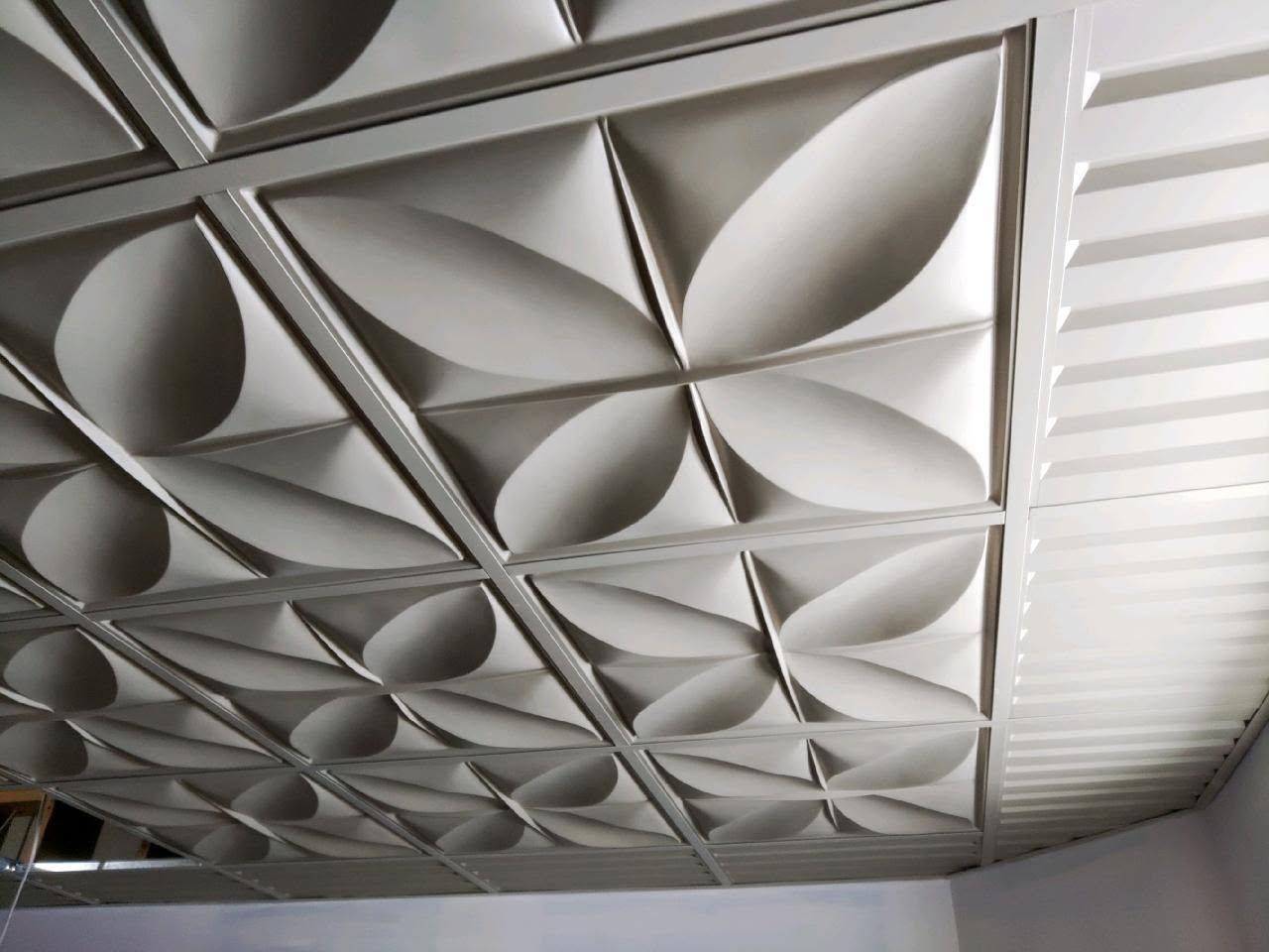 Geometric ceiling panels with repeating circular and diamond shapes in gray and white.