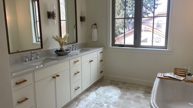 A hallway with hardwood floors and white shelves leading to a staircase.