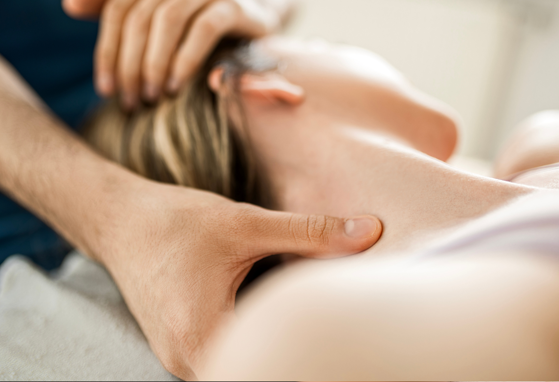 A man is giving a woman a massage on her neck.