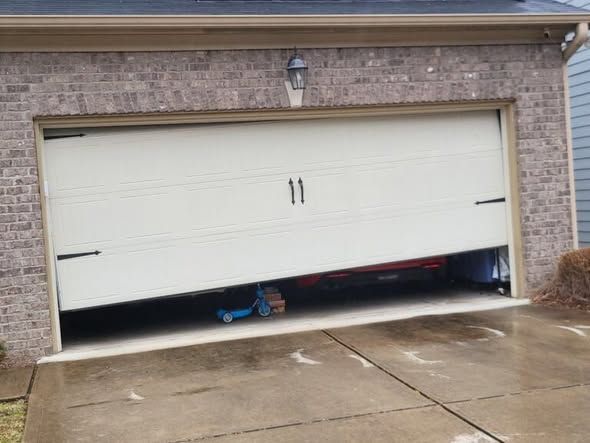 Partially open garage door with a child’s toy car trapped underneath