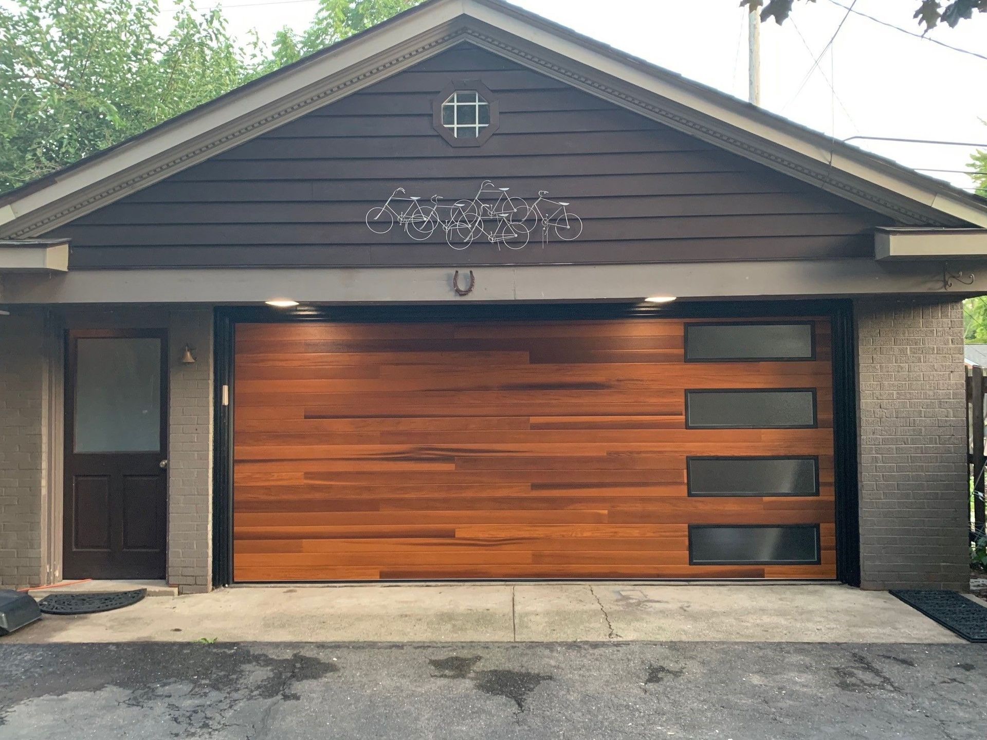 Modern house exterior with a wood garage door and dark siding