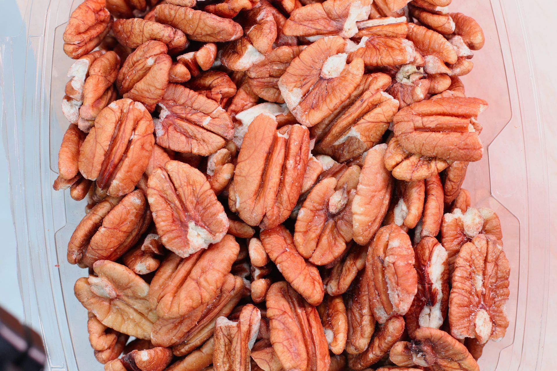 Close-up of a pile of brown pecans in shells