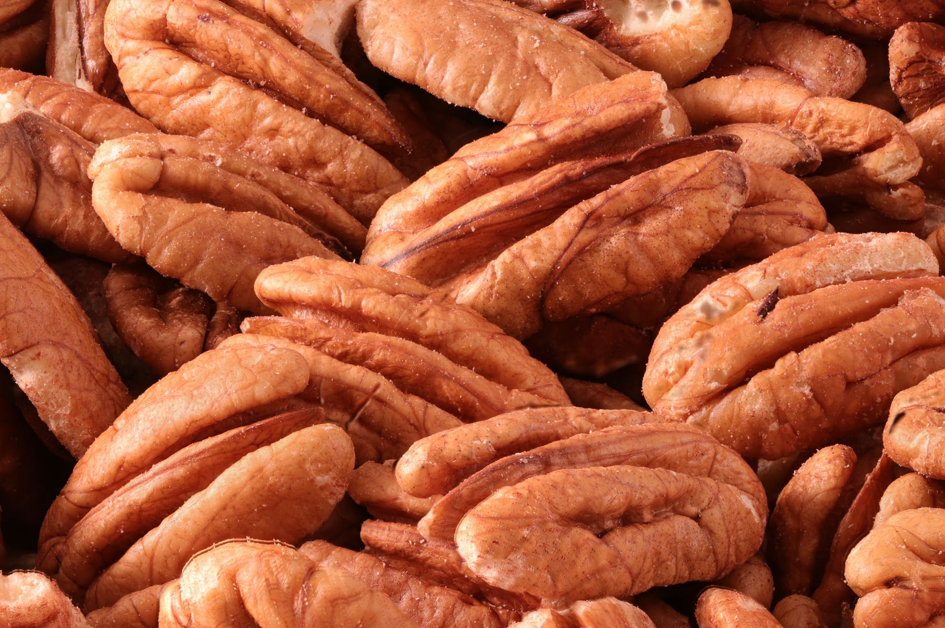 Close-up of a pile of brown pecans in shells