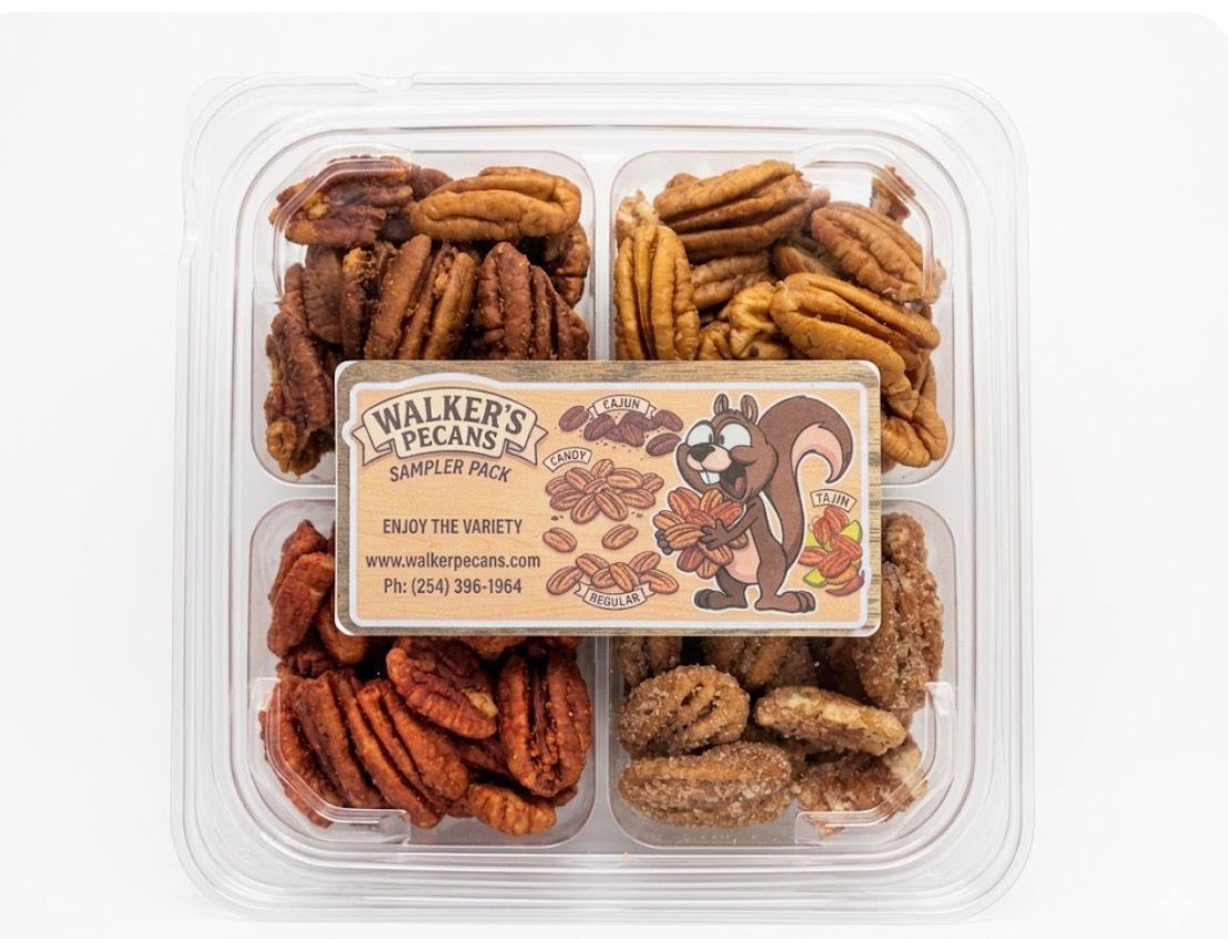 Assorted assorted Christmas cookies in a clear plastic tray with a holiday label in the center.