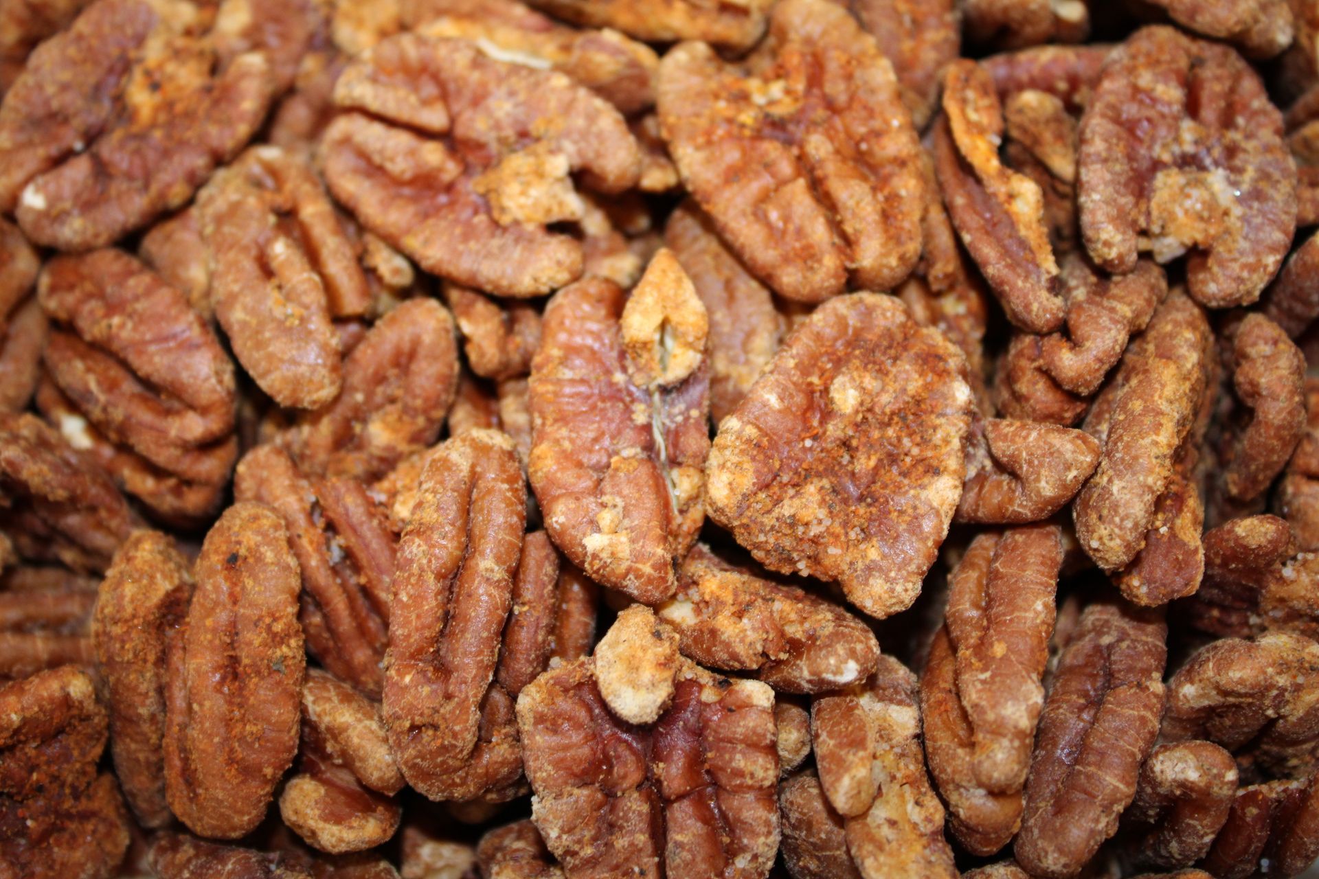 Close-up of candied pecans with a glossy, spiced brown coating