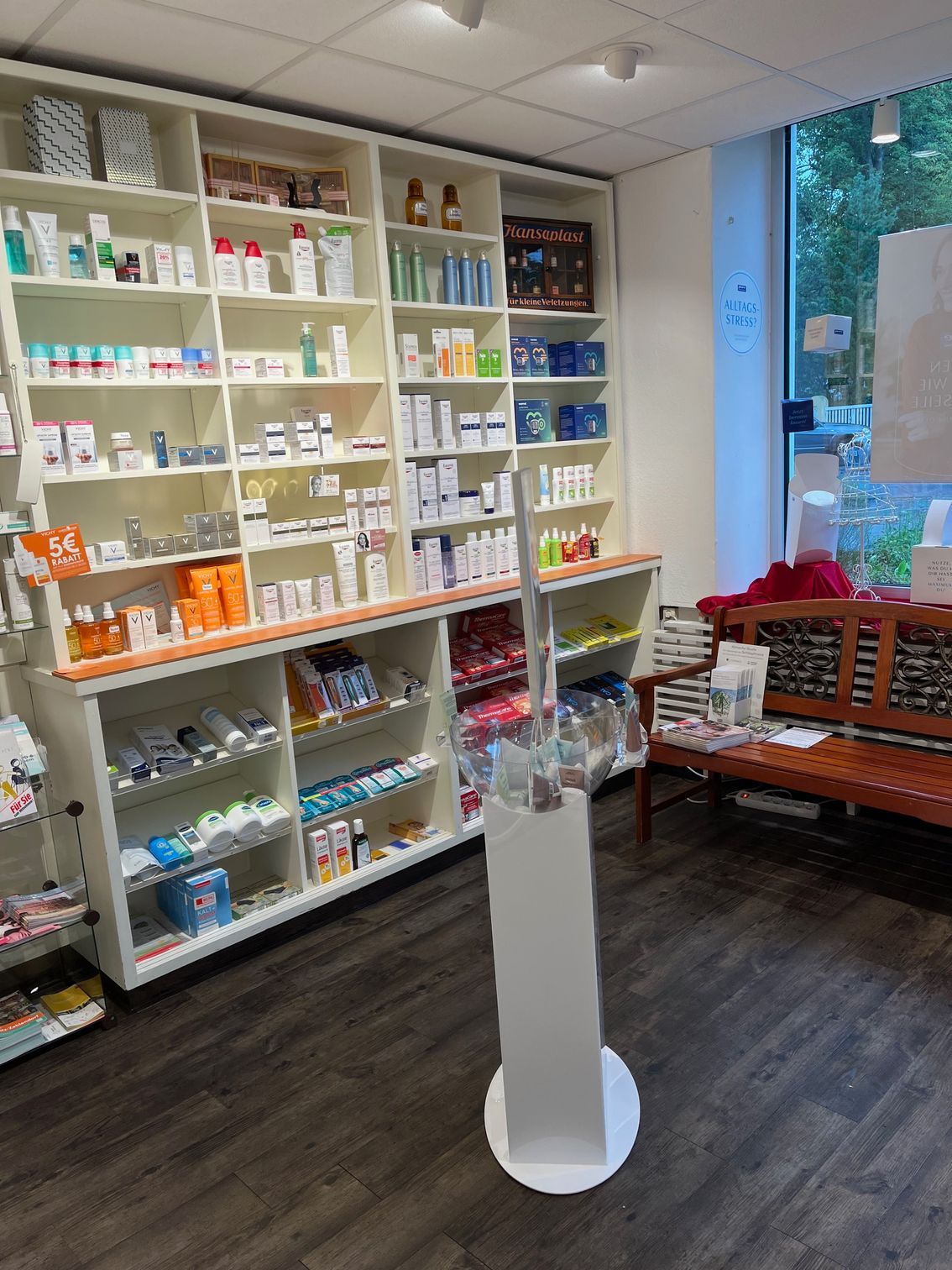 Eine Apotheke mit vielen Regalen und einer Bank